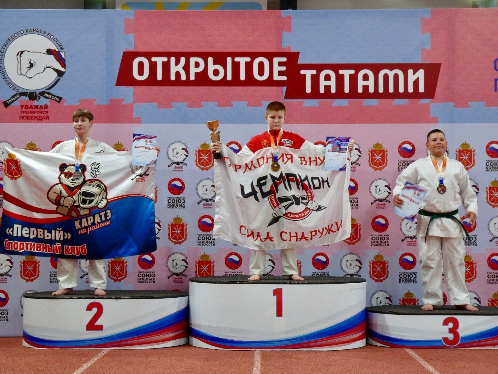 Чемпион и призёры с флагами на турнире «Открытое татами»